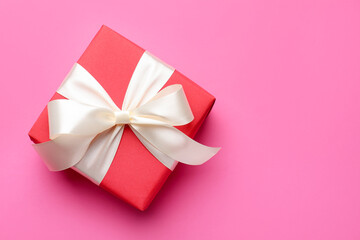 Beautiful gift on pink background, top view. Space for text