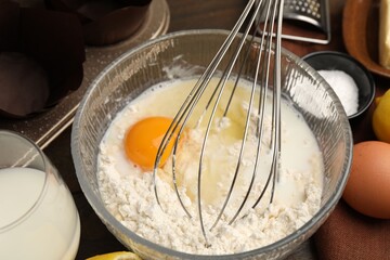 Ingredients for making muffins, whisk and cupcake tray on table, closeup