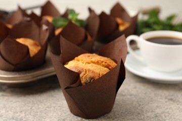 Tasty muffins with raisins, mint and coffee on grey table, closeup