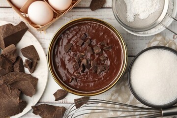 Naklejka premium Ingredients for making muffins and whisk on white wooden table, flat lay