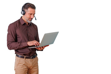 Man wearing an office headset with microphone, standing and typing on a laptop, providing customer service or remote support