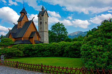 stary, drewniany kościół w górach, trawnik otoczony krzewami i drewnianym płotkiem © kateej