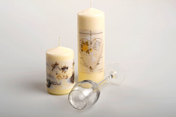 Dwie ozdobne świece i leżący kieliszek, dekoracyje świece, duża i mała świeczka, pusty kieliszek i świece, Two decorative candles and a lying glass
