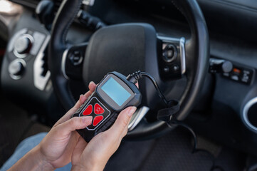 Woman using OBD2 diagnostic scanner. 