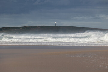 Lighthouse guiding through waves in stormy ocean weather