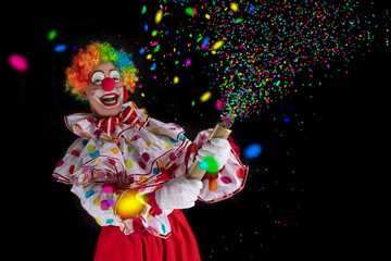 Funny clown pulling carnival cracker. Entertainer Joker in colorful suit and wig.Trickster, jester, pantomime, mime whiteface makeup. Professional actor at event, kids party, circus.