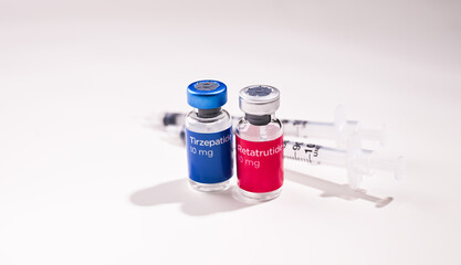 Close up of Retatrutide and Tirzepatide Vials with Single Use Insulin Syringes 