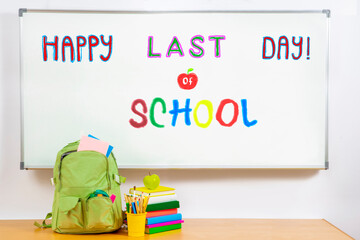 School Holidays concept. Fun colorful inscriptions in a children's style on white school board. Backpack, notebooks, textbooks, school stationery
