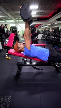 Side View of Man Performing Incline Dumbbell Bench Press on Adjustable Bench in Gym - Vertical Chest Workout