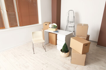 Fototapeta premium Workplace with cardboard boxes in rented office on moving day