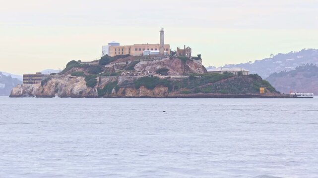 Historic prison cellhouse and buildings on Alcatraz Island surrounded by the cold waters of San Francisco Bay