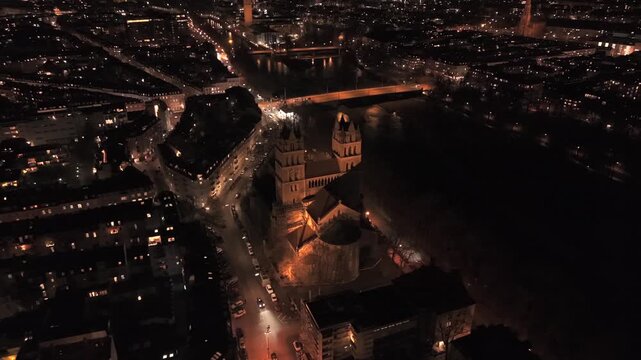 Luftaufnahme bei Nacht von St. Maximilian in Munchen, mit historischen Fassaden, heller Stadtbeleuchtung, klarer Blockstruktur und dem leuchtenden Verlauf der Isar im Zentrum.