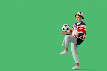 Fototapeta premium Female soccer fan with UK flag and ball on green background