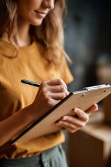 Person Writing on Clipboard in Modern Workspace