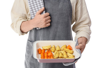 Young man with tasty vegetables in baking dish on white background