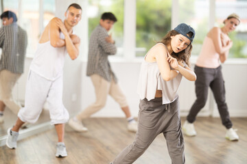 Group of young hip-hop dancers rehearsing in the studio. Dancers full of energy