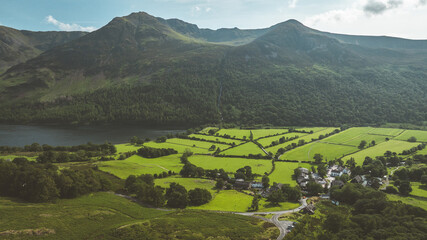 Scenic aerial view of a lush green valley with mountains and a lake