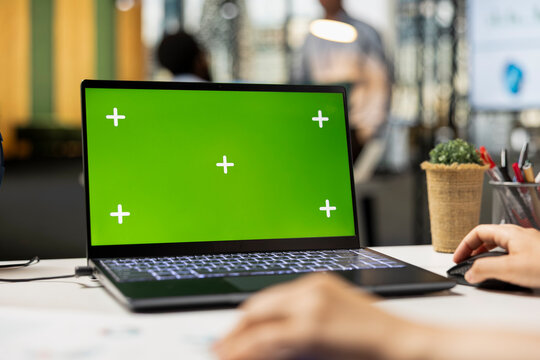 Corporate workspace with close up of laptop showing green screen mockup. Caucasian office worker analyzes financial statistics using isolated chroma key template on digital device. - Powered by Adobe