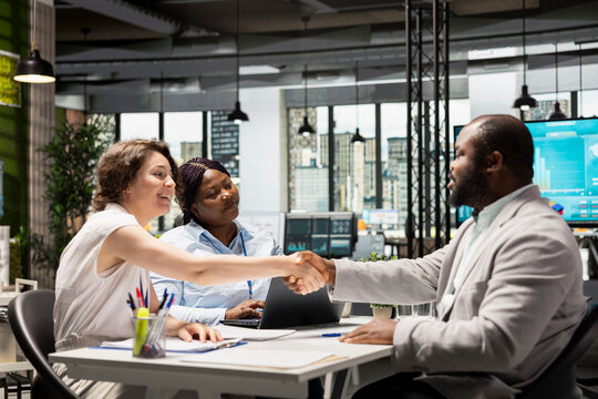 Handshake between HR manager and candidate for filling in the new position, legal terms and paperwork completed as the new employee prepares to join the team and start a successful career.