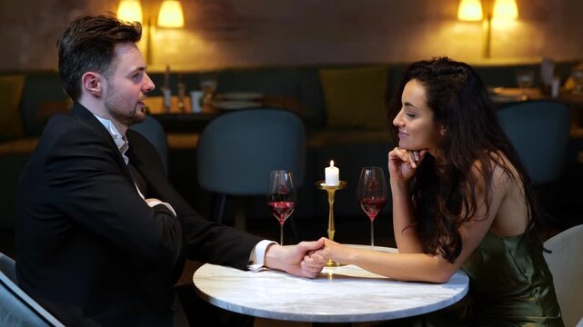 Young man holding box with ring making propose to his girlfriend during the date in the restaurant. Lifestyle, love, relationships concept. Slow motion