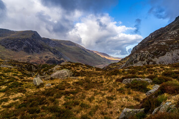 Dramatic Mountain Valley Landscape with Rocky Slopes, Heather Moorland and Sunlit Clouds in the Welsh Countryside