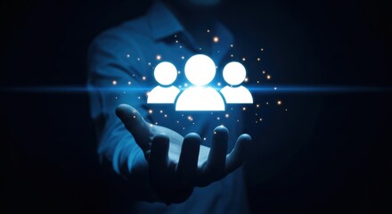 Human hand holding glowing digital people icons symbolizing teamwork connection and modern networking technology in a dark environment