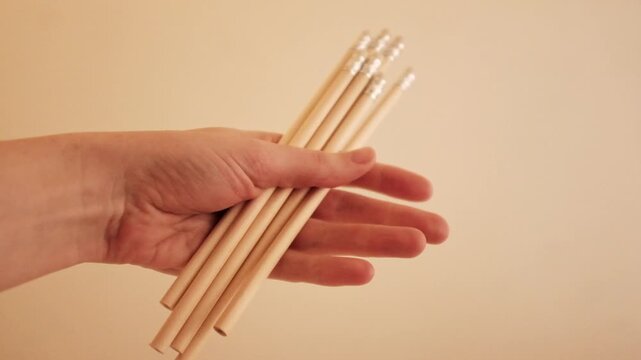 Closeup slow motion video of wooden graphite pencils. Simple minimalist pencils in Scandi style. School stationery in aesthetic colors. Back to school and educational concept. 