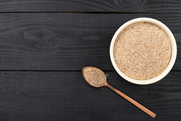 Psyllium husk powder with fresh leaves on wooden background, top view © Liami