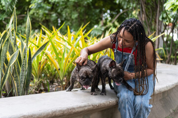 Woman enjoying mindful routine petting french bulldogs in park