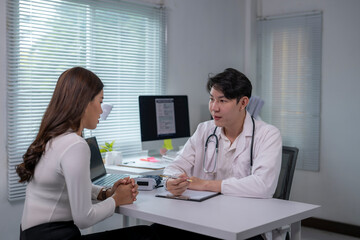 Obraz premium Asian doctor discussing diagnosis with a patient in his office during a medical consultation