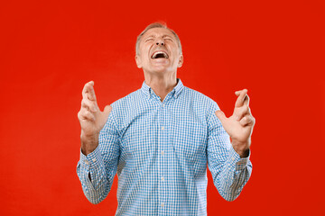 A man in a blue checkered shirt shows a clear sign of frustration. He raises his hands and tilts...