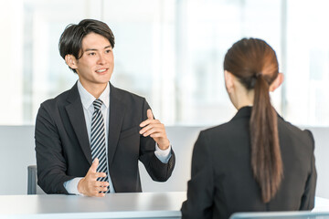 A young Asian businessman having a business meeting with a female customer or businesswoman
