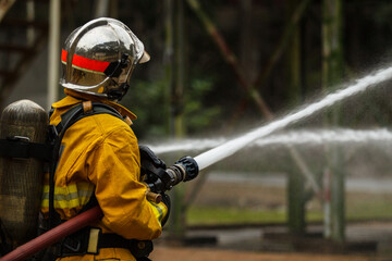 Firefighters using hose to control flames during emergency response