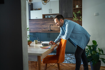 Man doing remote work from home office kitchen