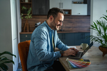 Man freelancing from home office researching color swatches