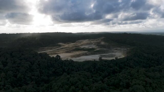 Aerial shot of a cilacap limestone mine quarry surrounded by nusakambangan island dense forest ideal for nature, industry, and environmental themes.