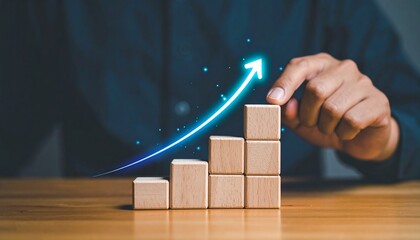 Hand building ascending bar graph with wooden blocks and a glowing upward arrow symbolizing business growth and success.