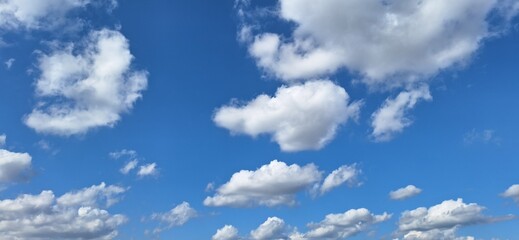 Beautiful blue sky with fluffy white clouds and copy space for background