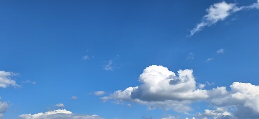 Beautiful blue sky with fluffy white clouds and copy space for background