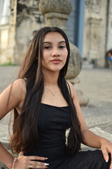 Fototapeta premium Portrait of a teenager wearing a black dress posing outdoors