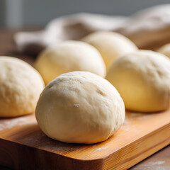 Fototapeta premium Freshly prepared dough balls resting on a wooden board, perfect for various baking projects and culinary creations.