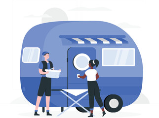 Two people preparing a blue camper van for travel outdoors
