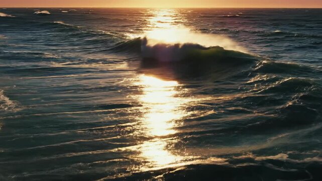 Golden hour aerial tracking shot following the glittering, rough ocean surface as powerful waves reflect the warm setting sun light liquid, setting, horizon