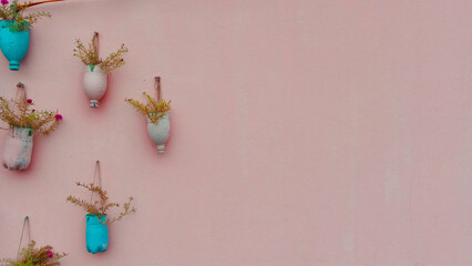 Minimal Wall Decor with Small Hanging Vases on Pastel Pink Background