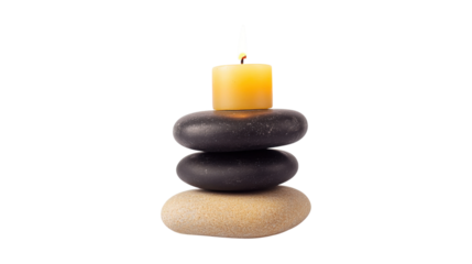 A candle is on top of three rocks. The candle is yellow and the rocks are black. Concept of calm and relaxation, as the candle and rocks are arranged in a way that suggests a peaceful setting