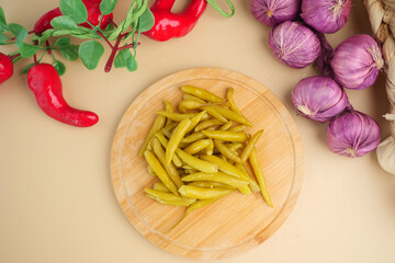pepper pickle and onions on a cutting board in a kitchen,
