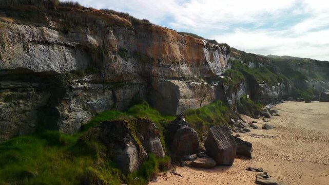 Aerial drone gliding left above Santa Cruz beach and ocean in front of coastal cliff in Portugal
