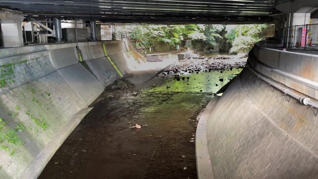 Ikuta River flows beneath railway tracks of Shin Kobe Station in Japan