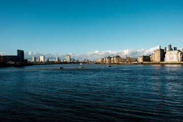 Obraz premium River thames flowing through london cityscape on a clear day