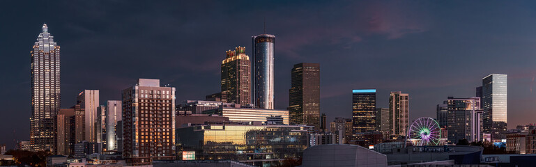 View of the Atlanta skyline showing several prominent buildings, hotels, office towers at night following sunset
